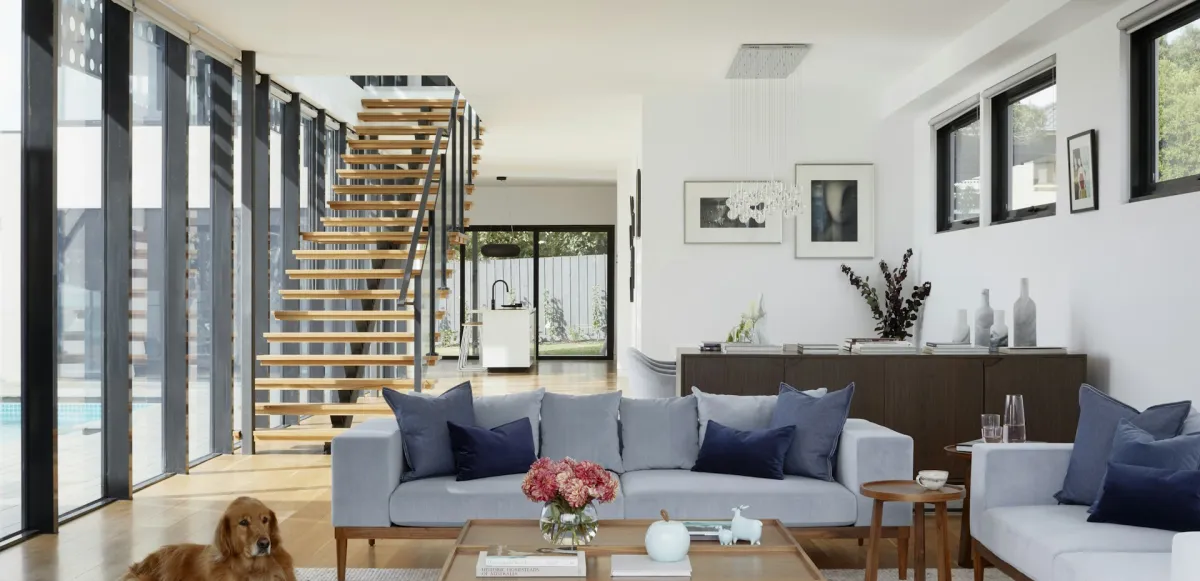 Salón luminoso con escalera abierta y materiales cálidos