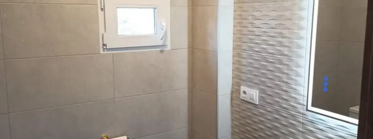 Baño reformado con mueble y revestimientos claros