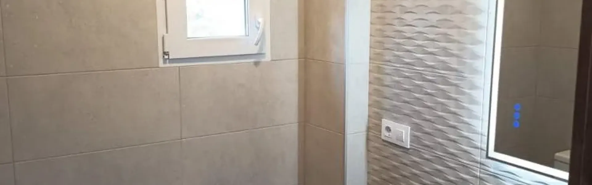 Baño reformado con mueble y revestimientos claros