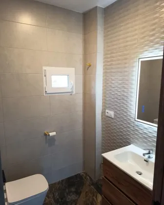 Baño reformado con mueble y revestimientos claros