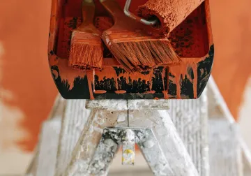 Herramientas y bandeja de pintura sobre una escalera