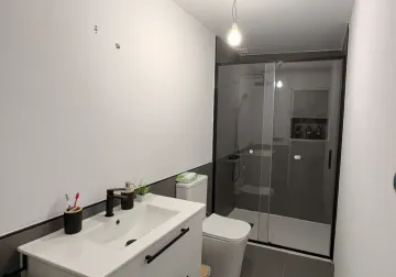 Zona de ducha con mampara y revestimiento cerámico